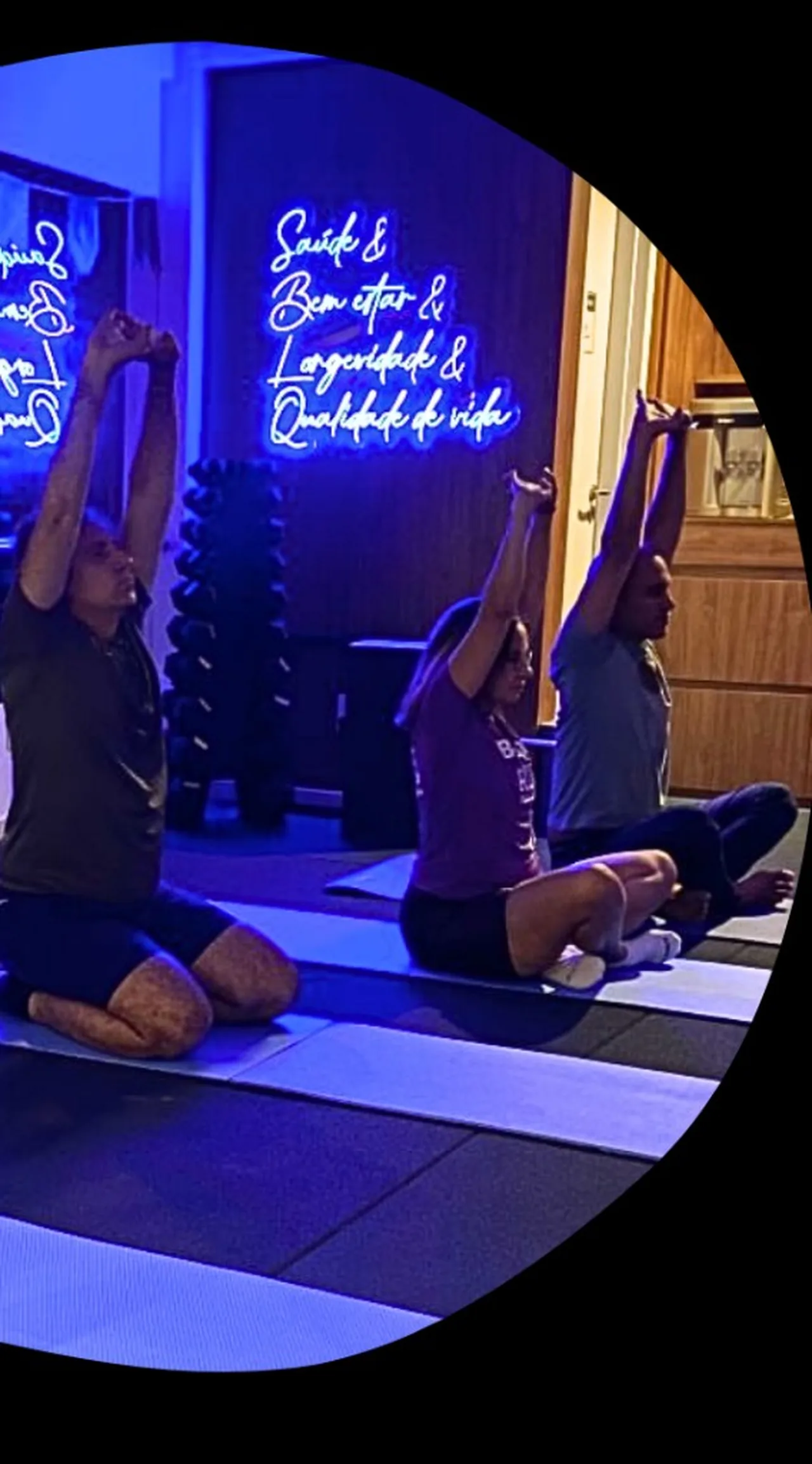Alunos em aula de yoga no Estúdio Longevos, com braços elevados